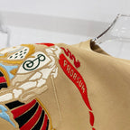 Tan T-shirt close-up with embroidered cartoon horse and red banner details
