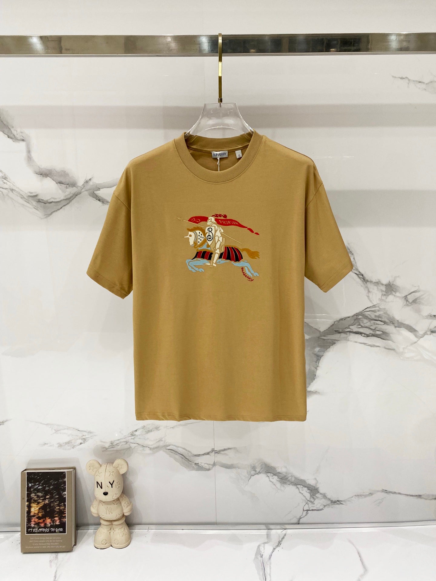 Tan short-sleeve T-shirt with multicolor cartoon horse graphic at center