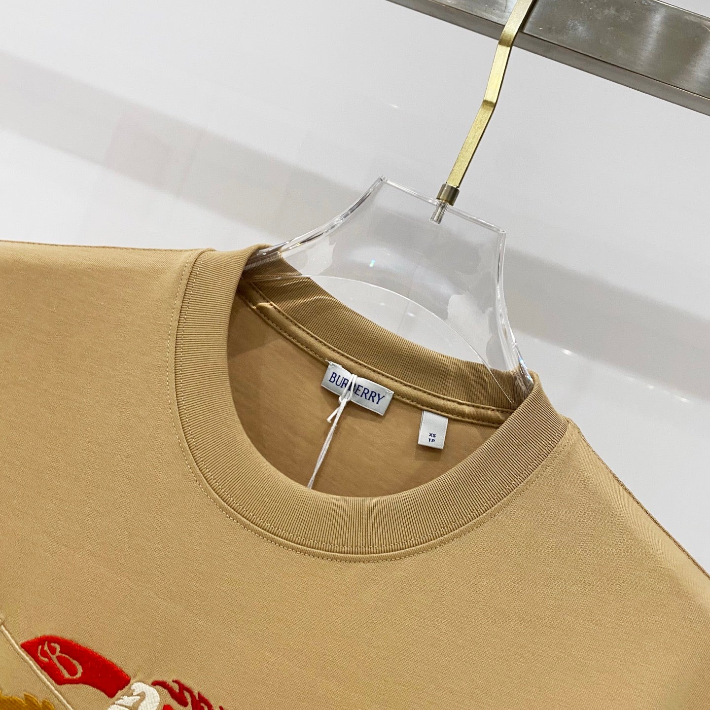 Tan short-sleeve T-shirt neckline with Burberry logo label and ribbed collar