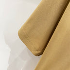 Tan T-shirt sleeve cuff and hem seam close-up