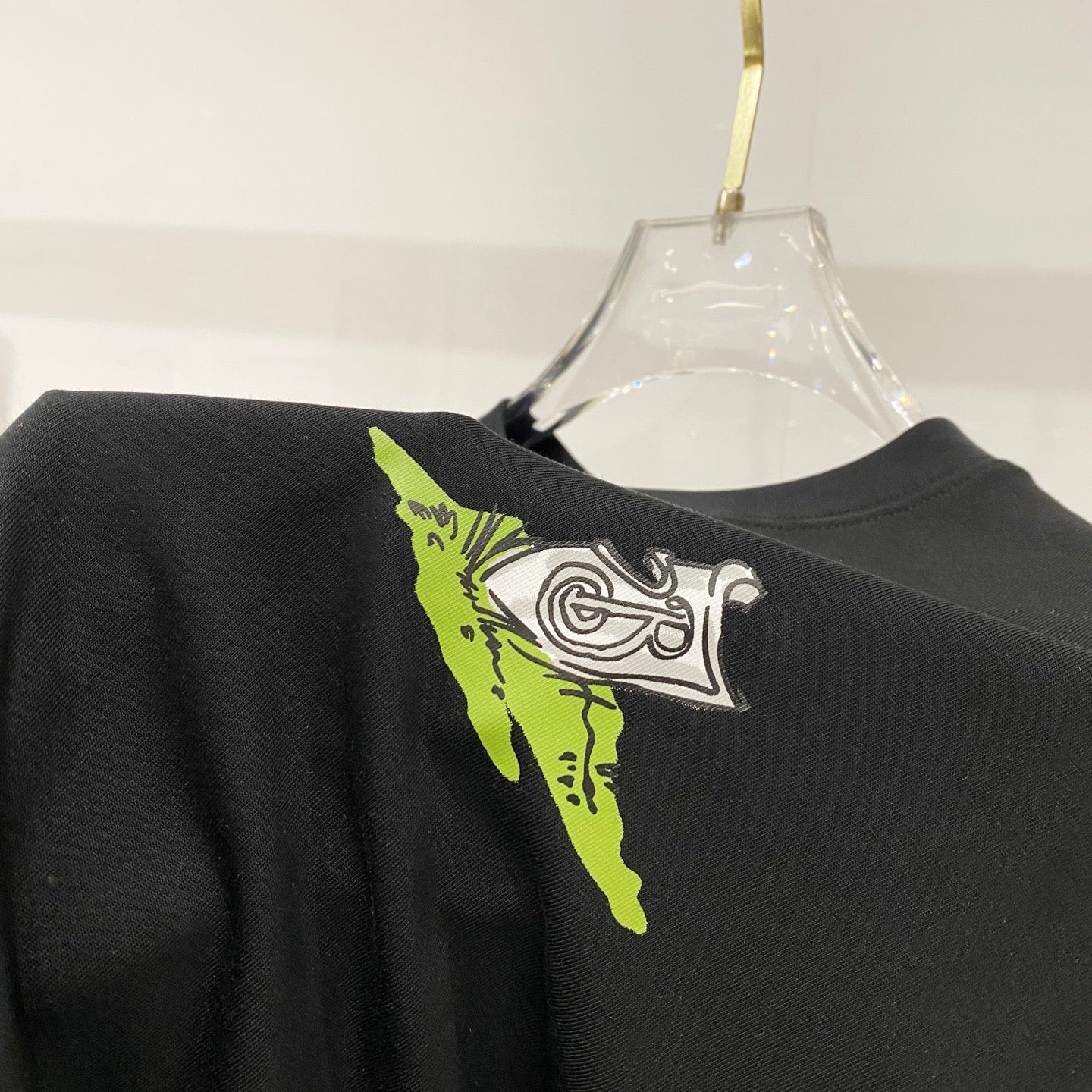 Black crewneck T-shirt with neon green and white logo-style print