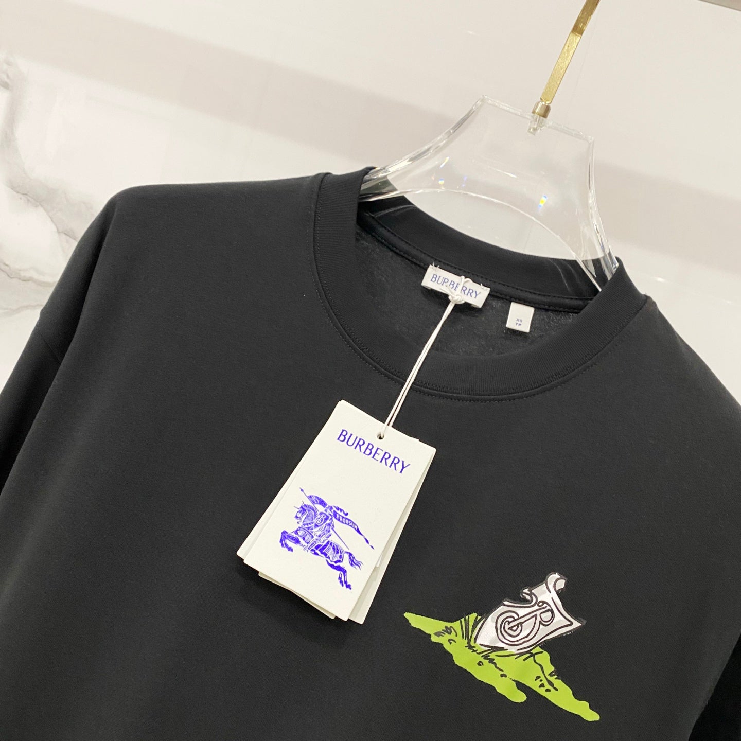 Black crewneck T-shirt with neon green and white graphic; Burberry tag attached