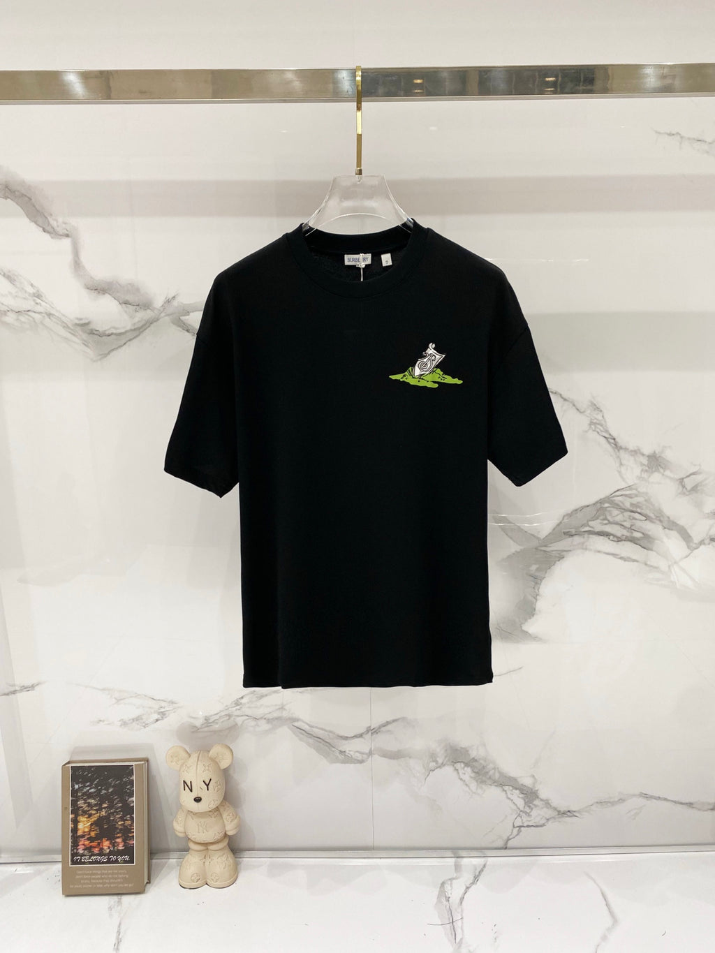 Black crewneck T-shirt with small neon green character graphic