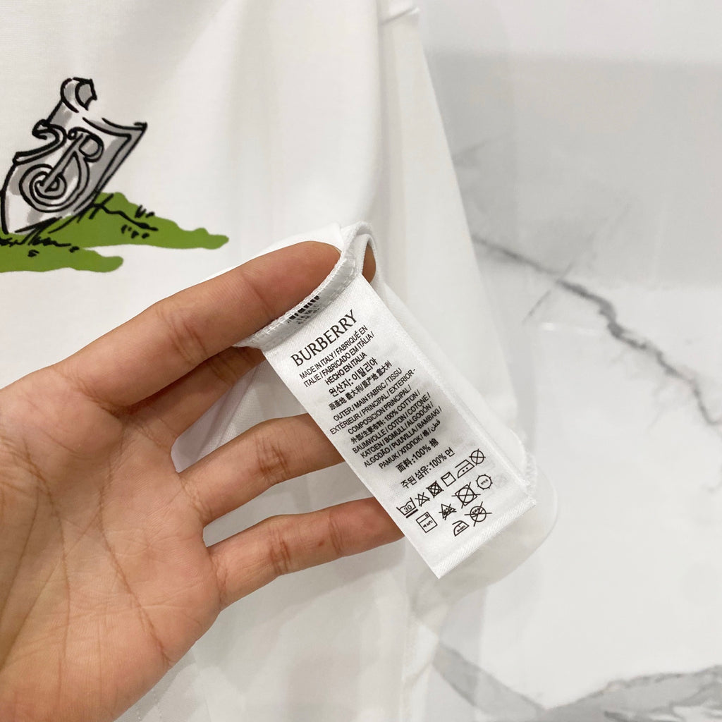 Burberry white T-shirt care label tag in hand, with stitched neck seam