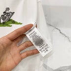 Burberry white T-shirt care label tag in hand, with stitched neck seam