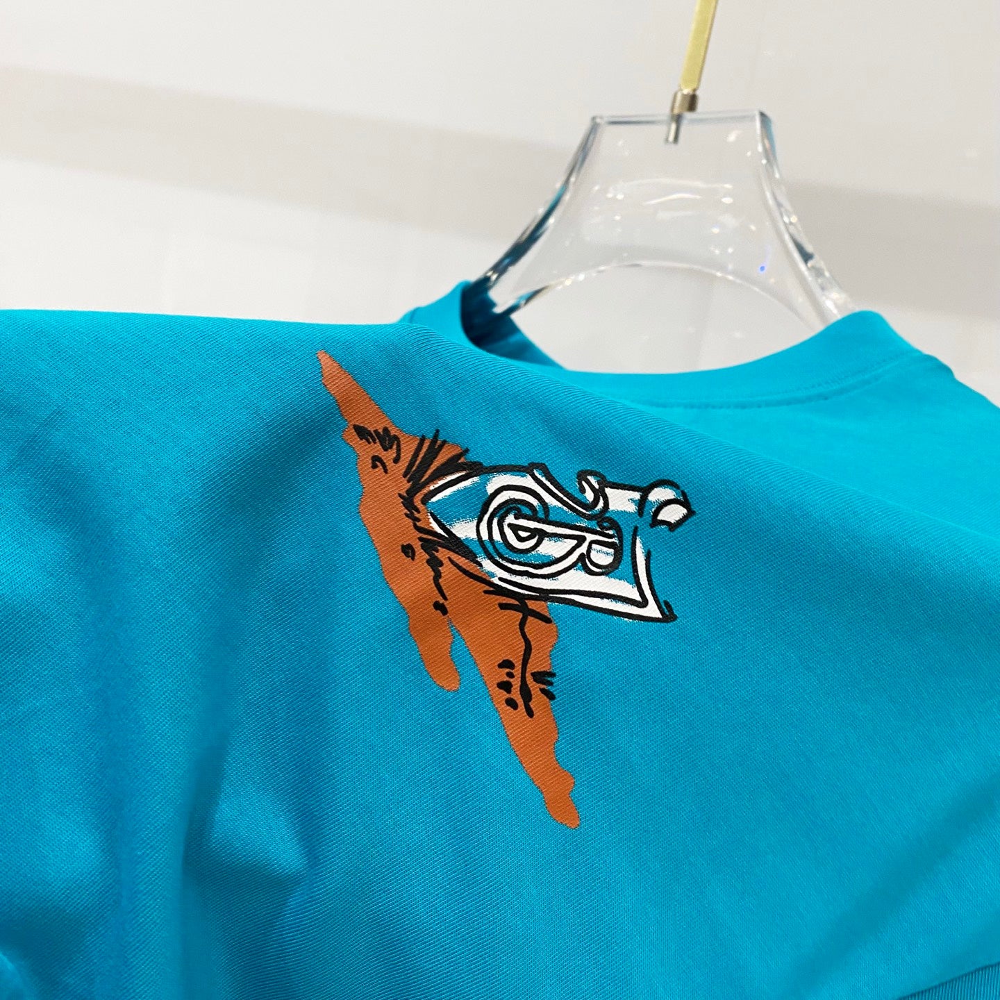 Turquoise T-shirt with illustrated bird graphic on the front