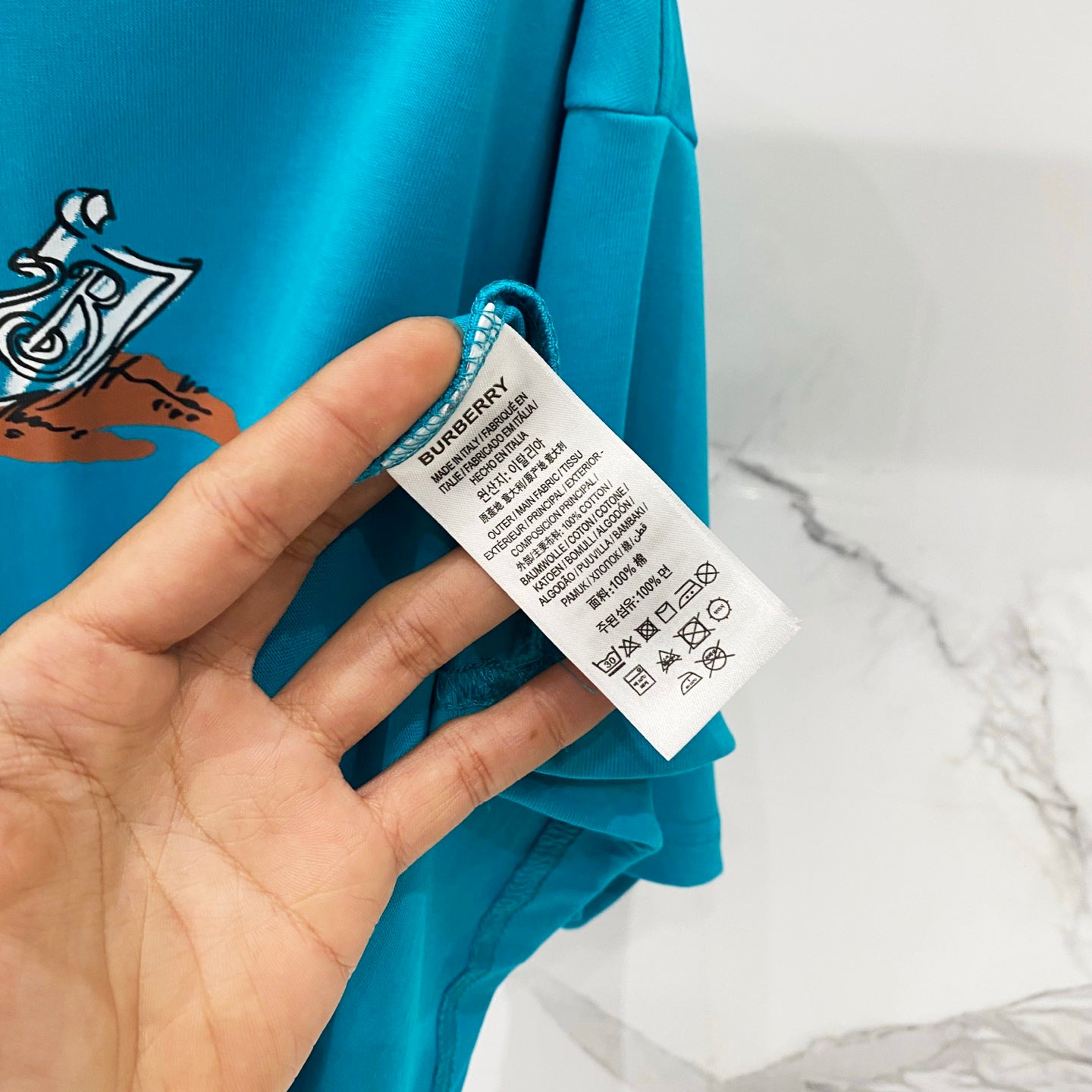 Turquoise T-shirt with Burberry care label on the inner side seam