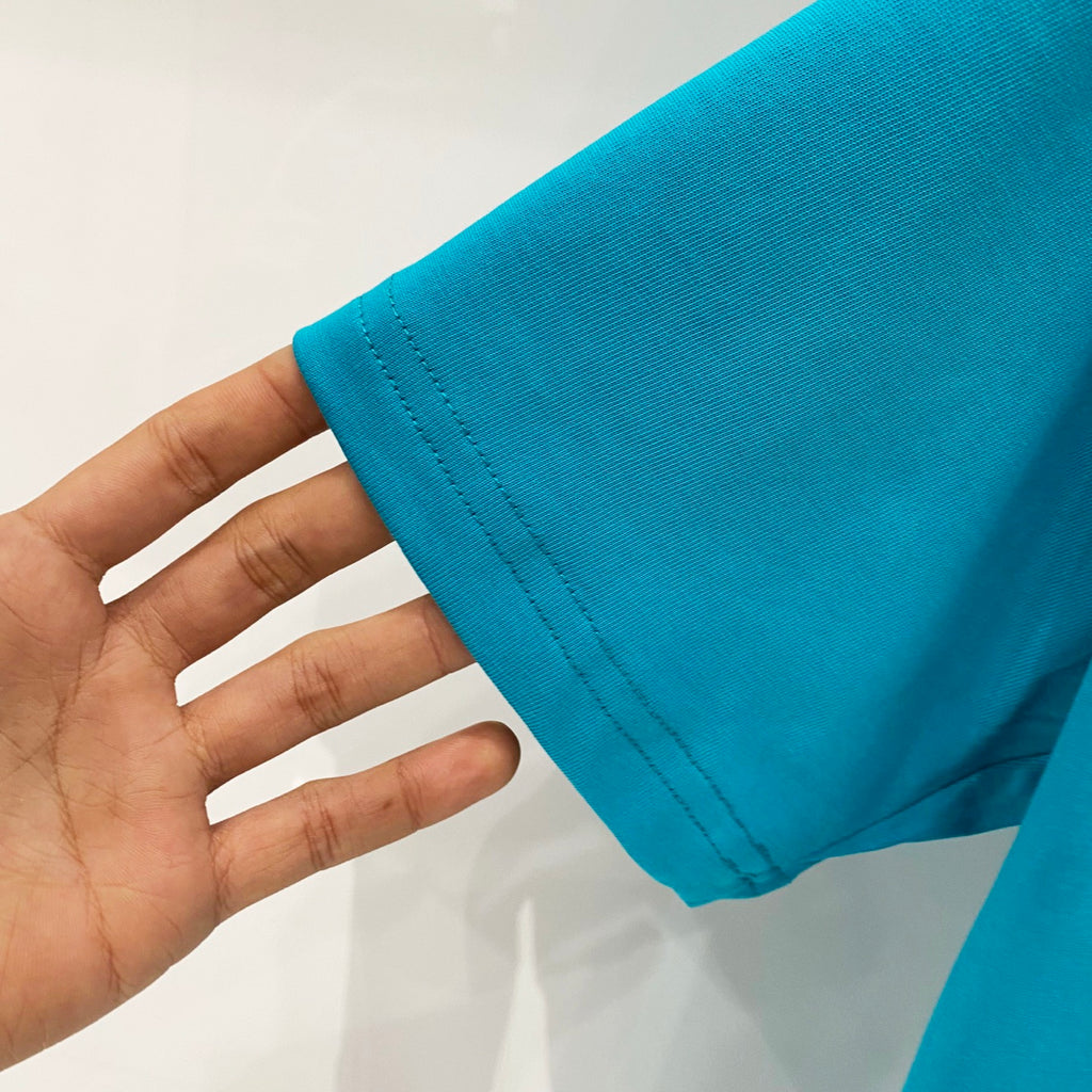 Turquoise T-shirt sleeve hem with visible stitching