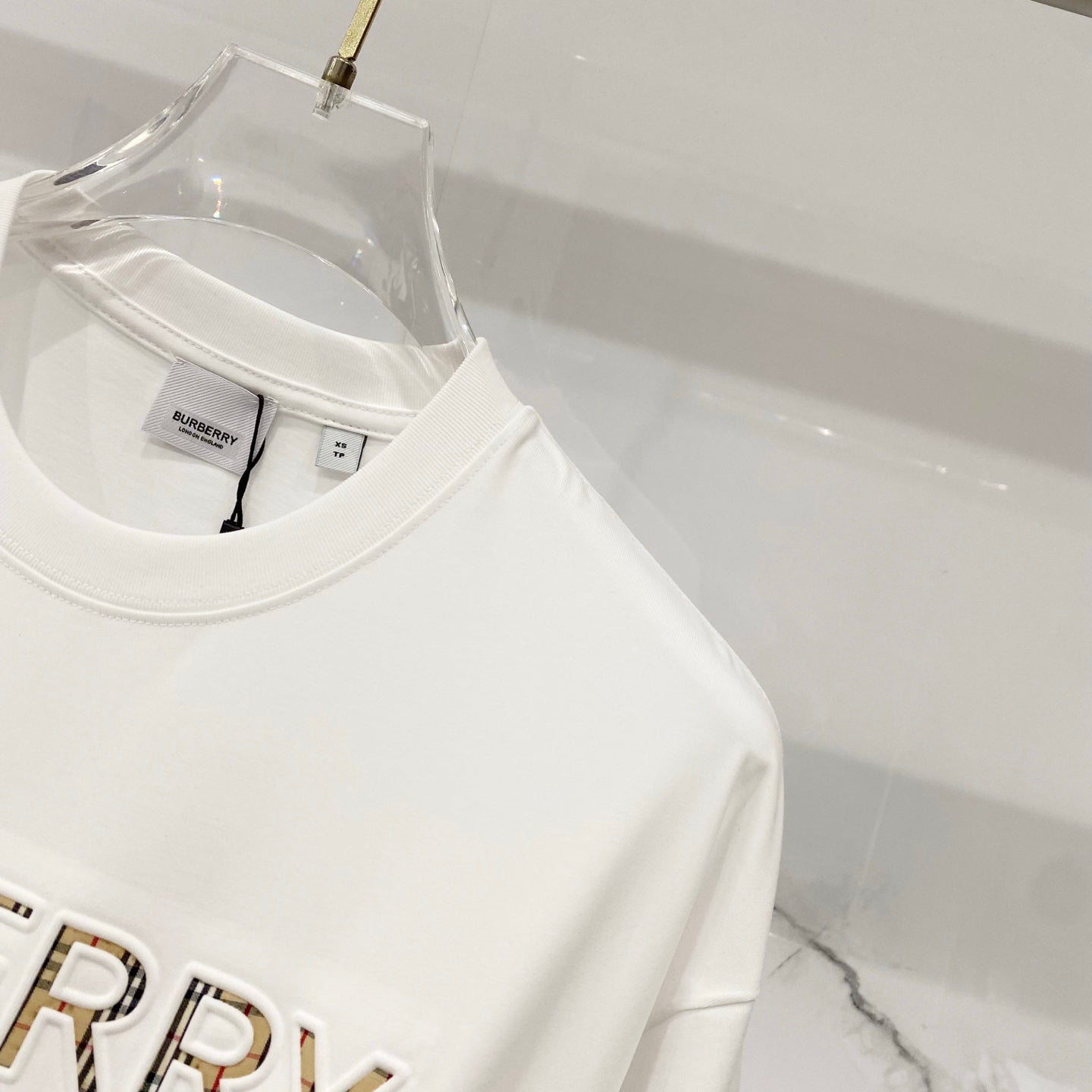 White T-shirt on hanger with crew neck and partial 'BURBERRY' logo
