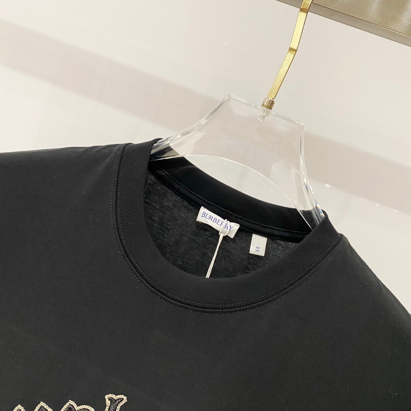 Black crewneck T-shirt neckline with Burberry brand tag on inner collar