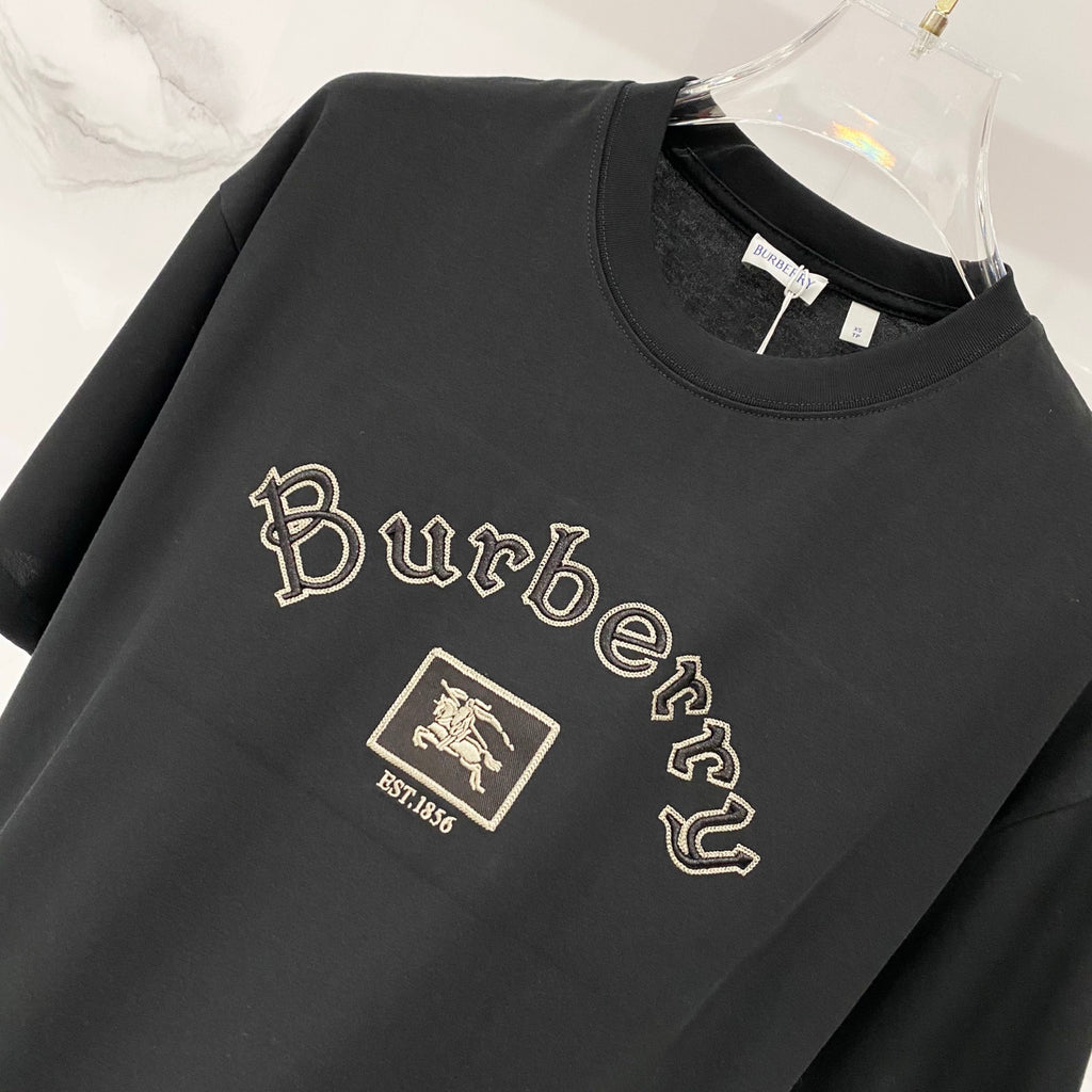 Black crewneck T-shirt with large gold Burberry script and crest emblem