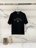 Black crewneck T-shirt with Burberry-style gold embroidery logo