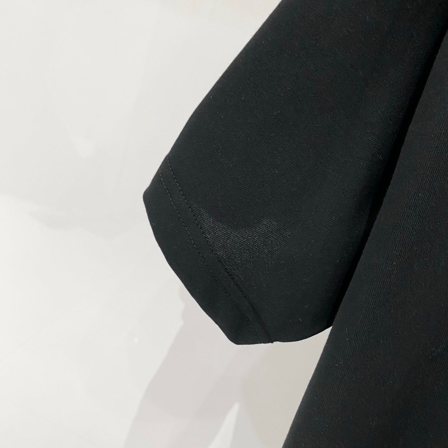 Black short-sleeve T-shirt hem and side seam close-up
