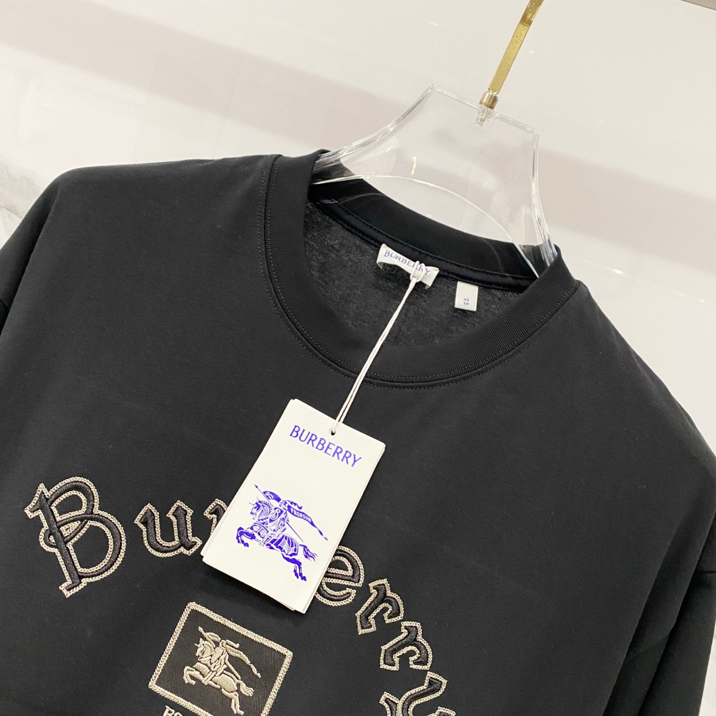 Black crewneck T-shirt with gold Burberry crest patch and script embroidery