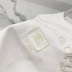White T-shirt sleeve detail with stitched crest patch and “Burberry” embroidery