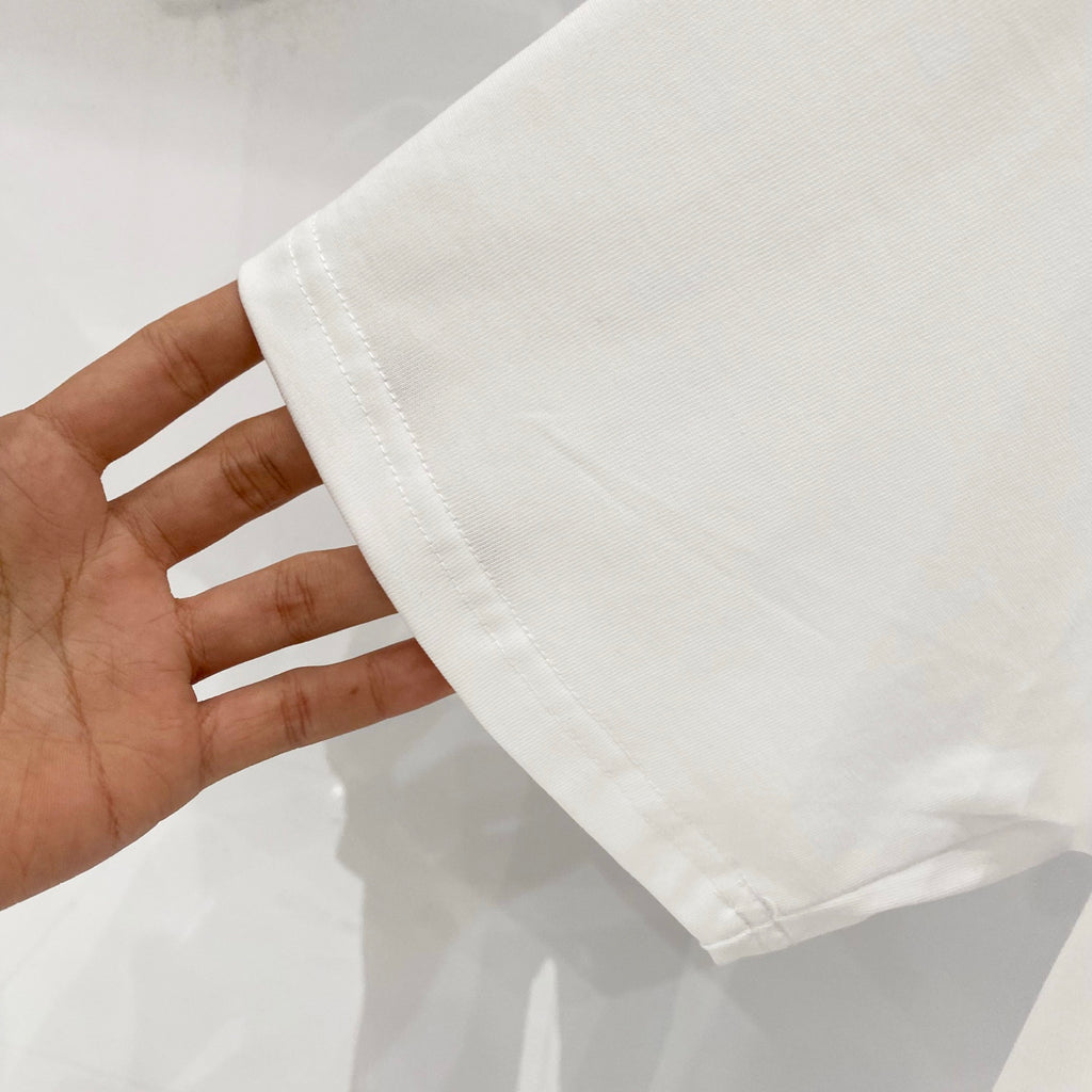 White T-shirt cuff and short sleeve hem, shown in hand
