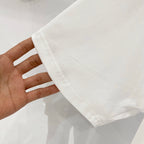 White T-shirt cuff and short sleeve hem, shown in hand
