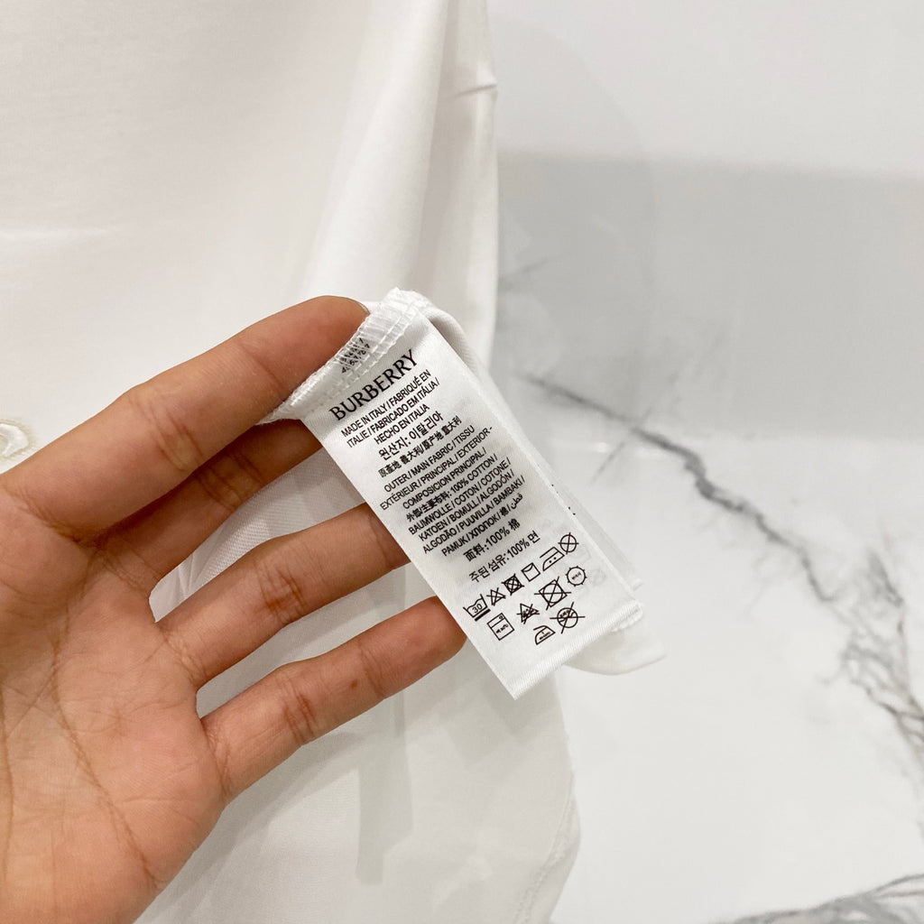 White T-shirt fabric tag with Burberry branding and care information