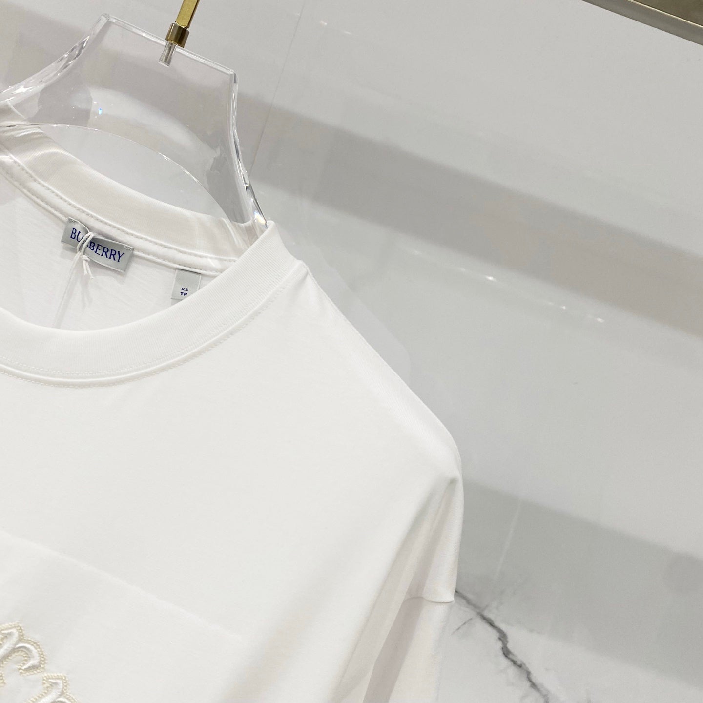 White short-sleeve T-shirt side view with clean hem and crew neckline
