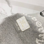 Grey T-shirt with embroidered “Burberry” text and small logo patch detail