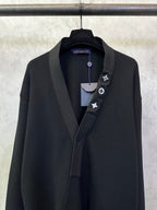 Black long coat front close-up with shawl lapel and decorative lapel icon trim