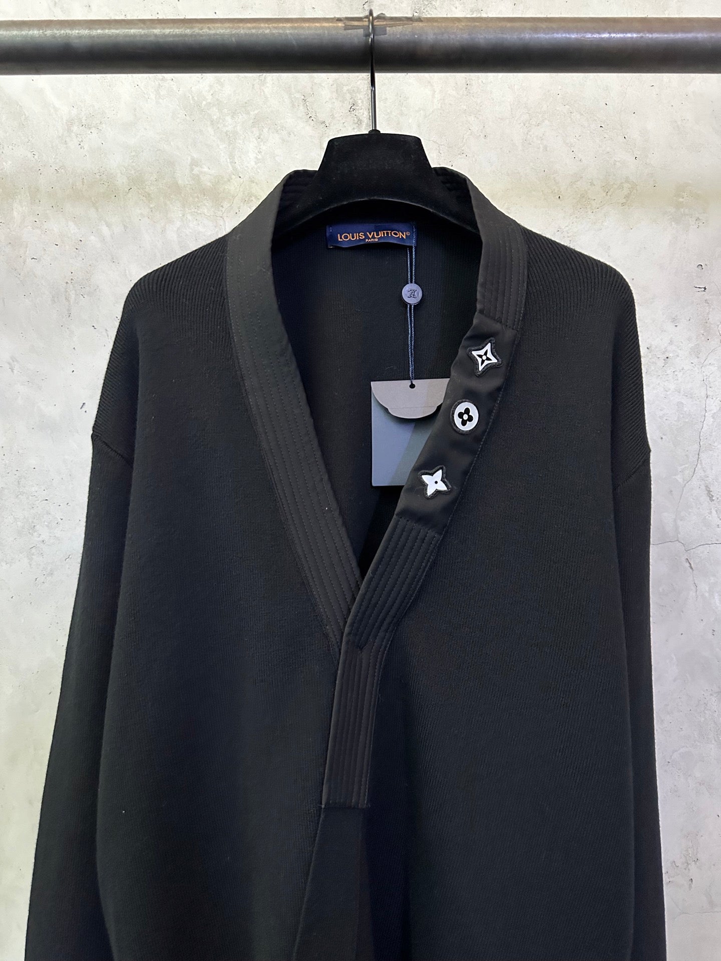 Black long coat front close-up with shawl lapel and decorative lapel icon trim