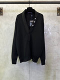 Black long coat with shawl lapels and decorative lapel icons on a hanging hanger