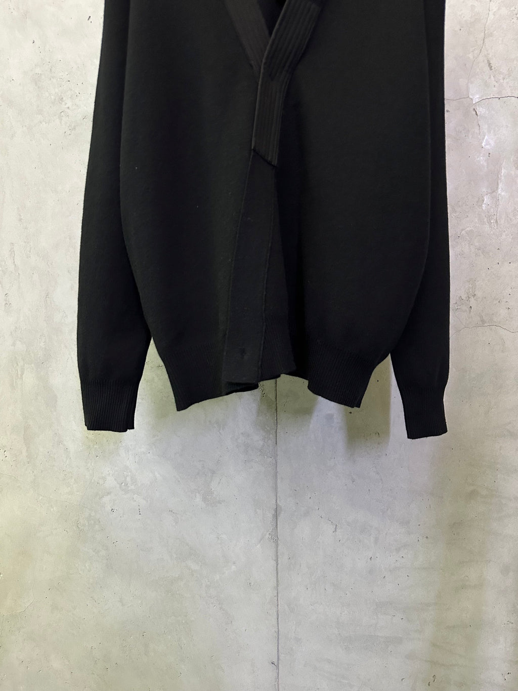 Black long coat front lower section with long sleeves and clean hemline