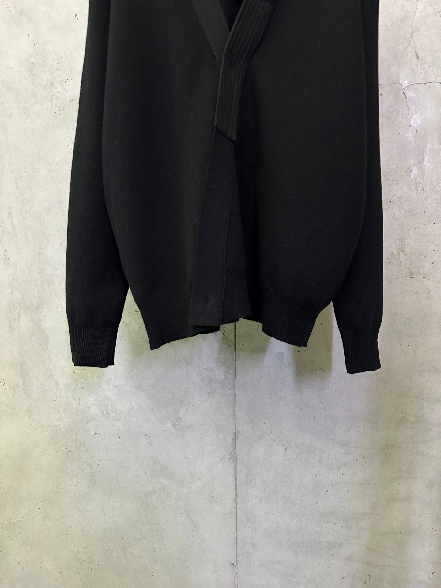 Black long coat front lower section with long sleeves and clean hemline