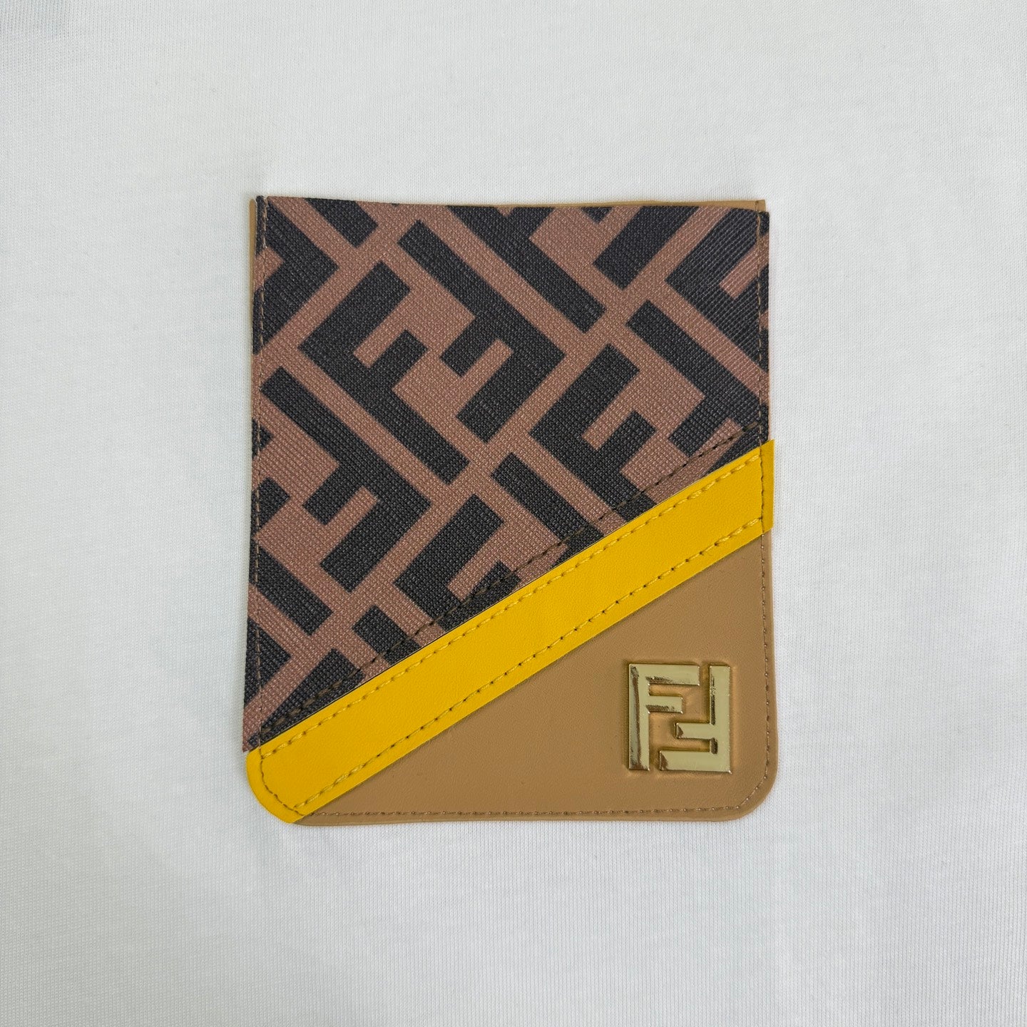 White Fendi T-shirt with brown-and-yellow logo patch at chest.