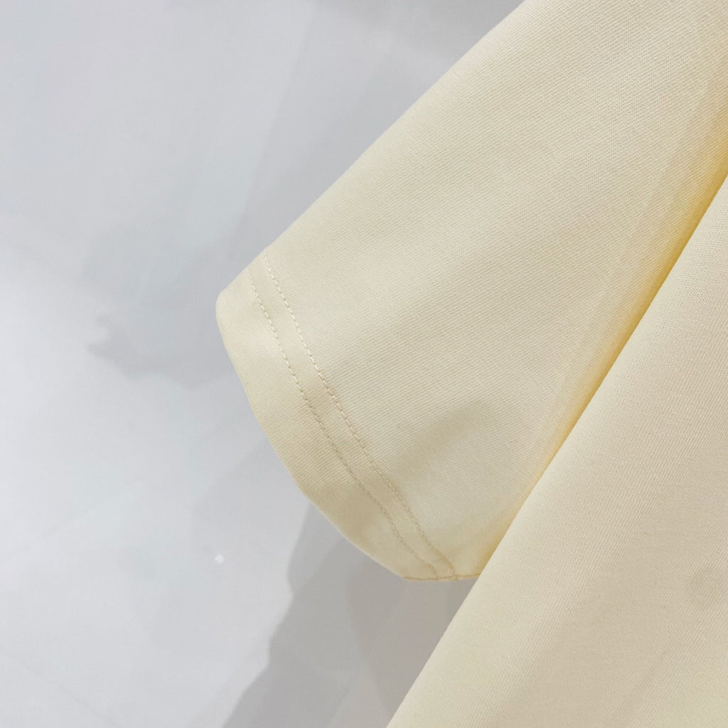 Pale yellow T-shirt fabric with stitched hem and side seam detail