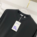 Black short-sleeve T-shirt close-up with crew neck and hanging label on chest.