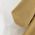Tan short-sleeve T-shirt sleeve cuff with visible hem stitching