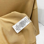 Tan short-sleeve T-shirt sleeve with care label tag
