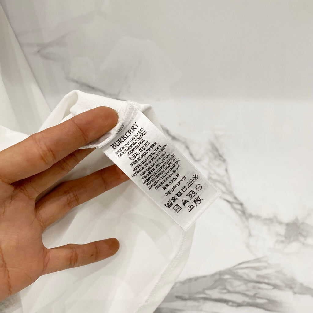 Kids white T-shirt fabric label with Burberry text and care instructions