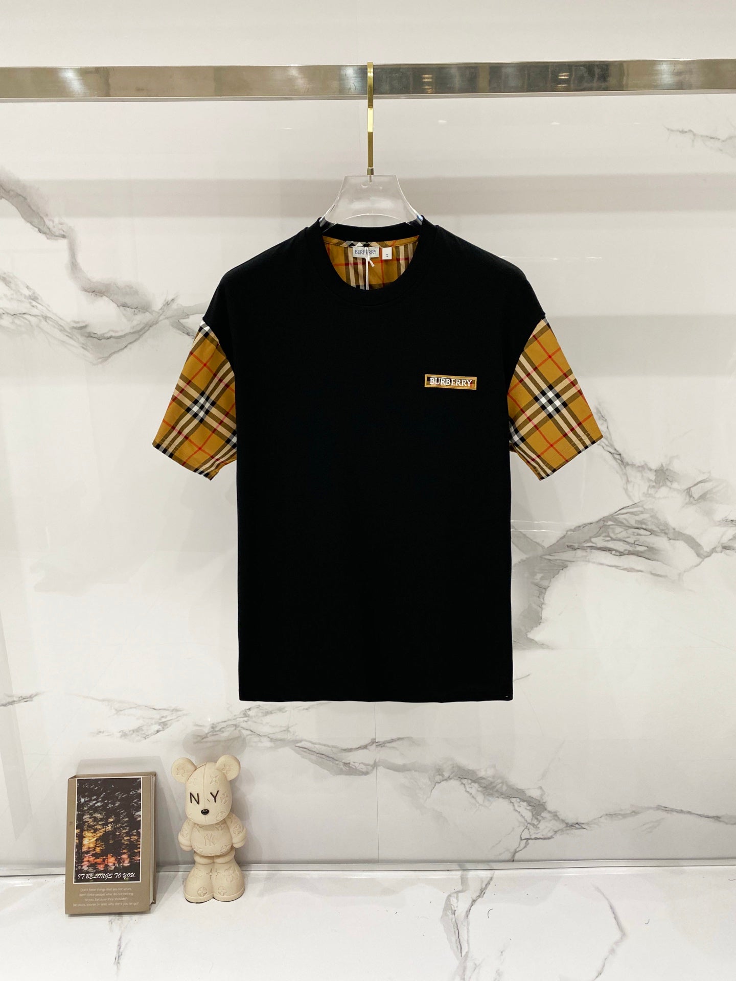 Black short-sleeve T-shirt with tan, red, and navy check sleeves