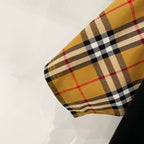 Close-up of check-pattern sleeve cuff in tan, red, black, and white