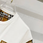 White T-shirt with plaid sleeve lining visible near the crew neckline