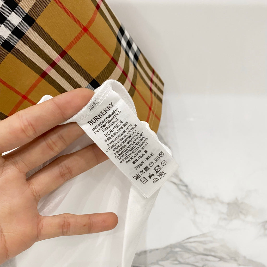 Inside neck label on white Burberry T-shirt with care and size text