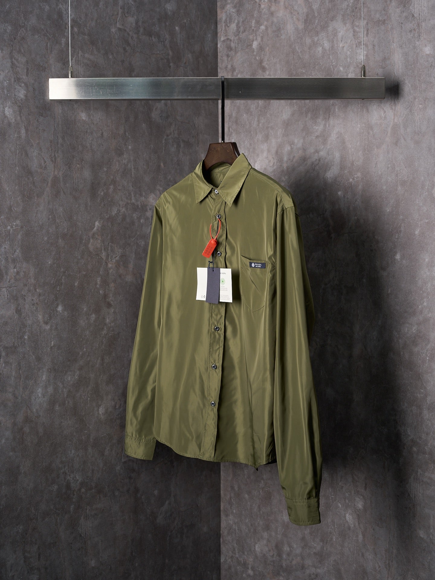 Olive Prada button-up shirt front view with chest pocket and hanging tags