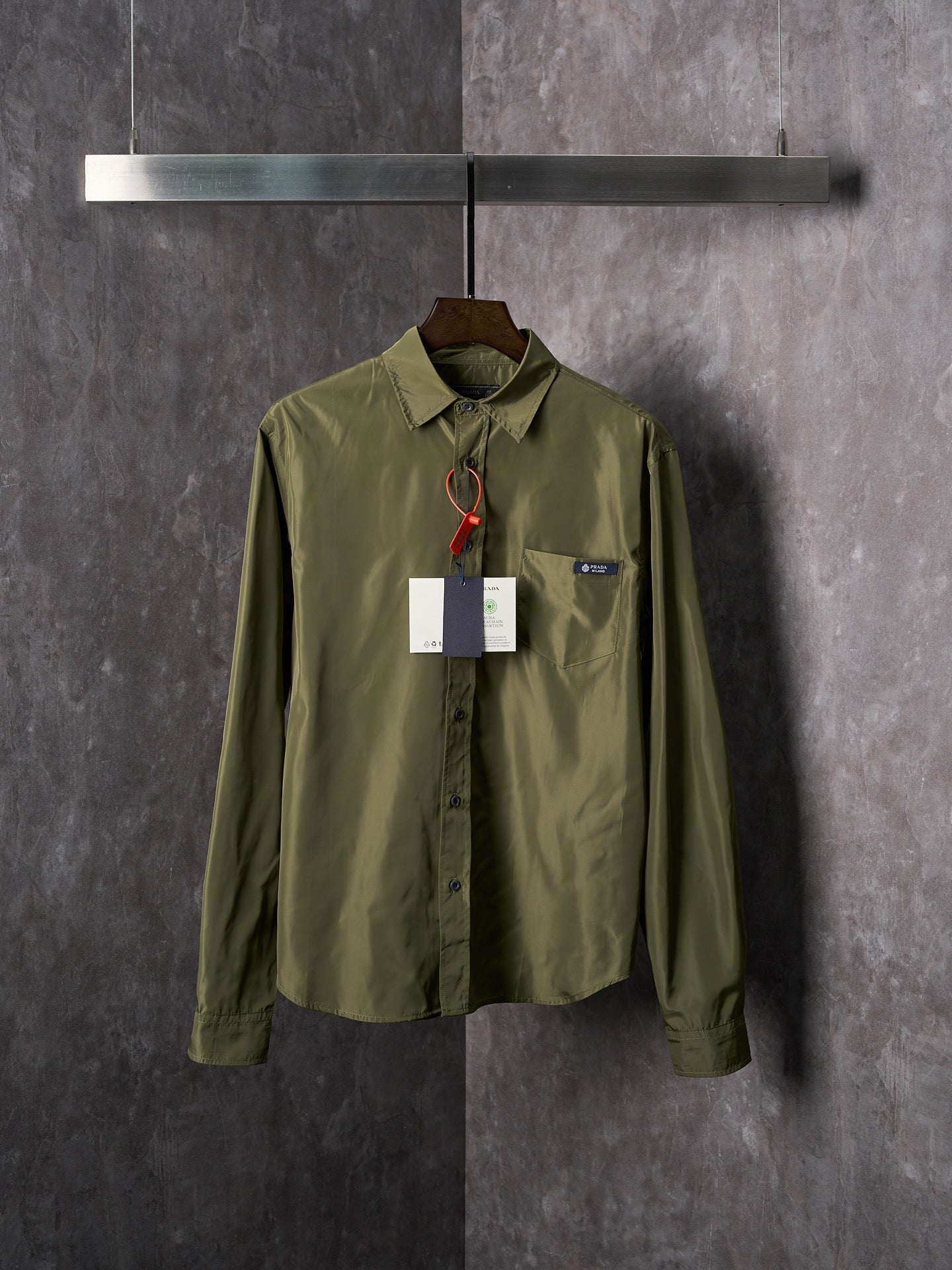 Olive Prada button-up shirt with pointed collar, button placket, and hanging tag