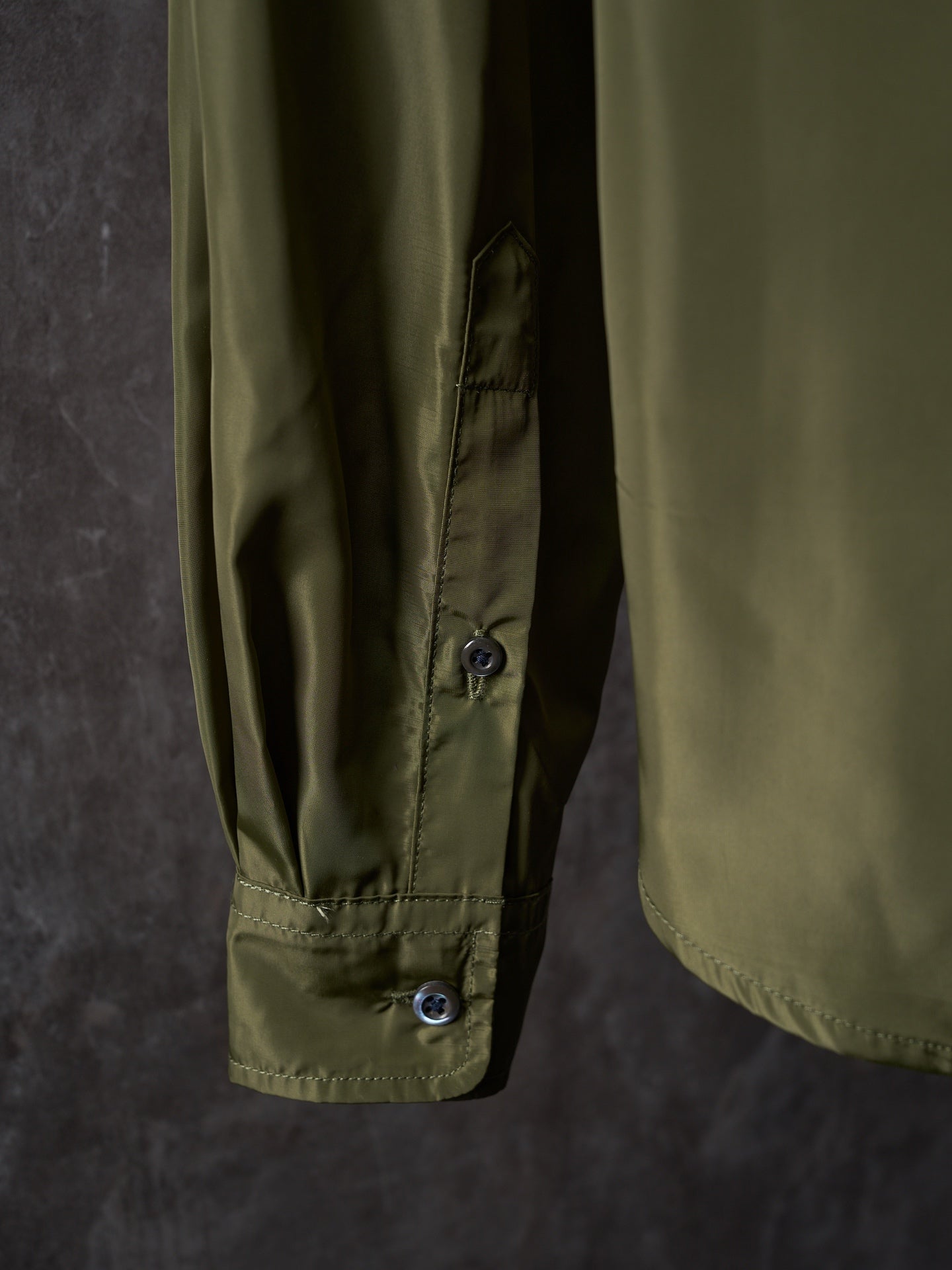 Olive Prada button-up shirt cuff with single button detail