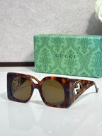 Gucci sunglasses with tortoiseshell frames and olive tinted lenses, gold logo detail