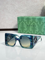 Gucci sunglasses with blue translucent frames and light tinted lenses, silver logo detail