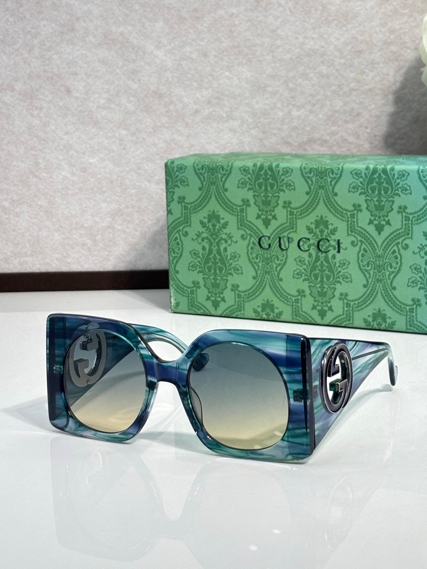 Gucci sunglasses with blue translucent frames and light tinted lenses, silver logo detail