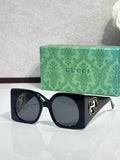 Gucci sunglasses with black square frames and dark tinted lenses, gold logo detail
