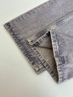 Folded light blue denim pants showing side seams and pocket panels