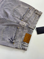 Light blue denim pants flat lay showing stitched pockets and gold button details