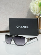 Chanel sunglasses with dark lenses, tortoise frame, gold emblem at the bridge
