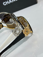 Sunglasses close-up: round silver and gold emblems on bridge, dark and amber lenses